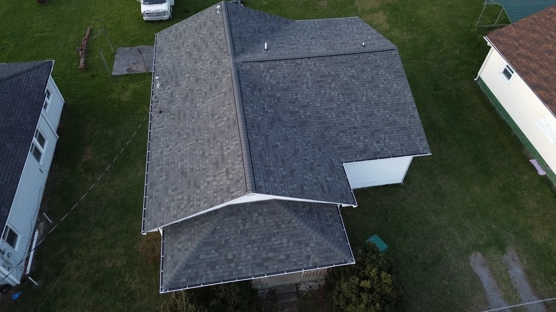 Overhead view of dark gray shingles on intersecting roof planes