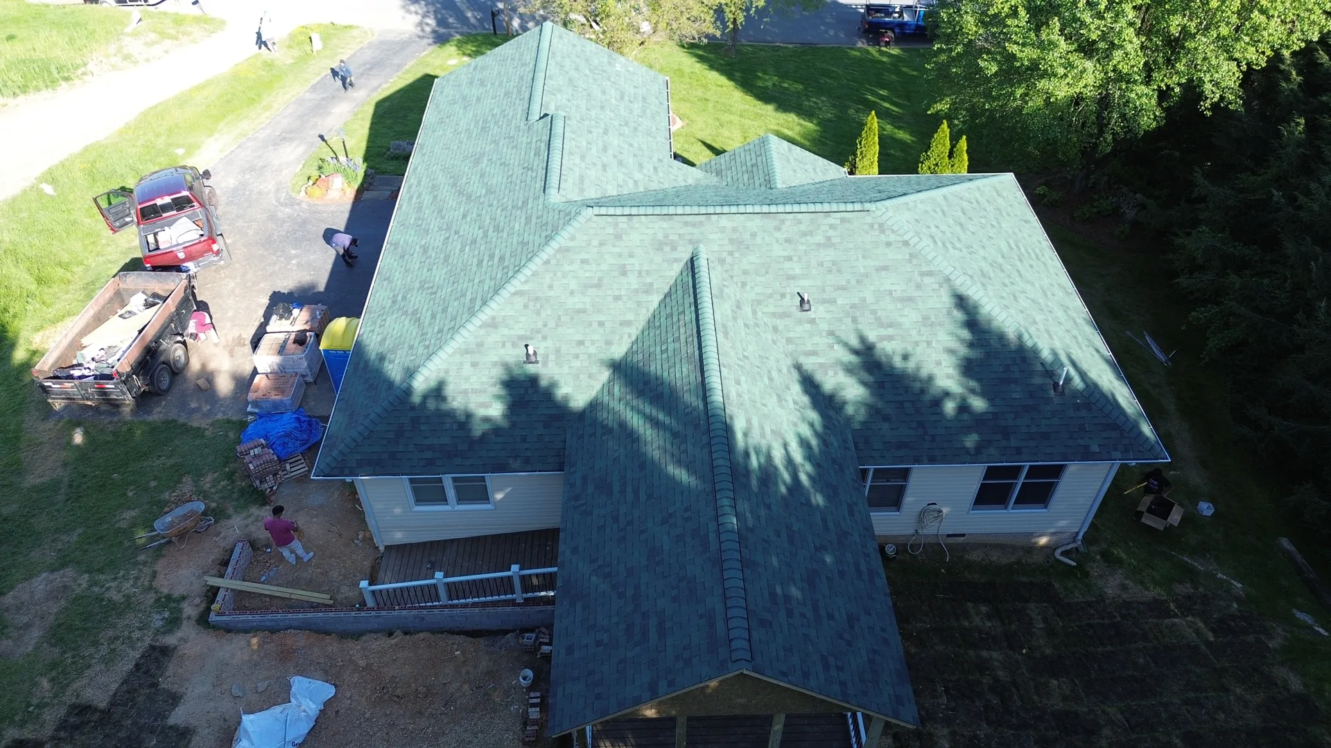 Aerial view of green-toned shingles on multiple roof planes