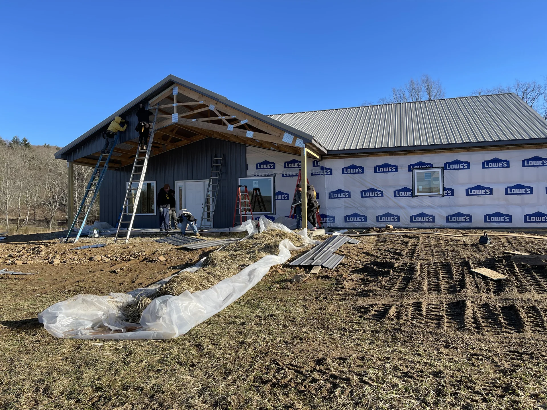 New construction with exposed porch framing and an unfinished roof