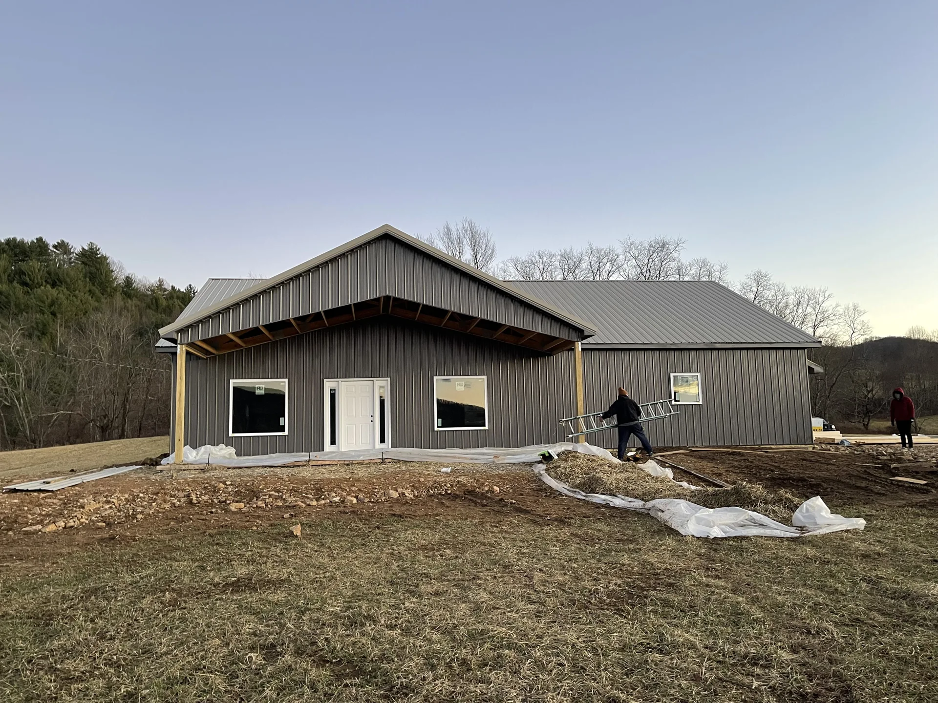 Single-story home under construction with dark roof slopes