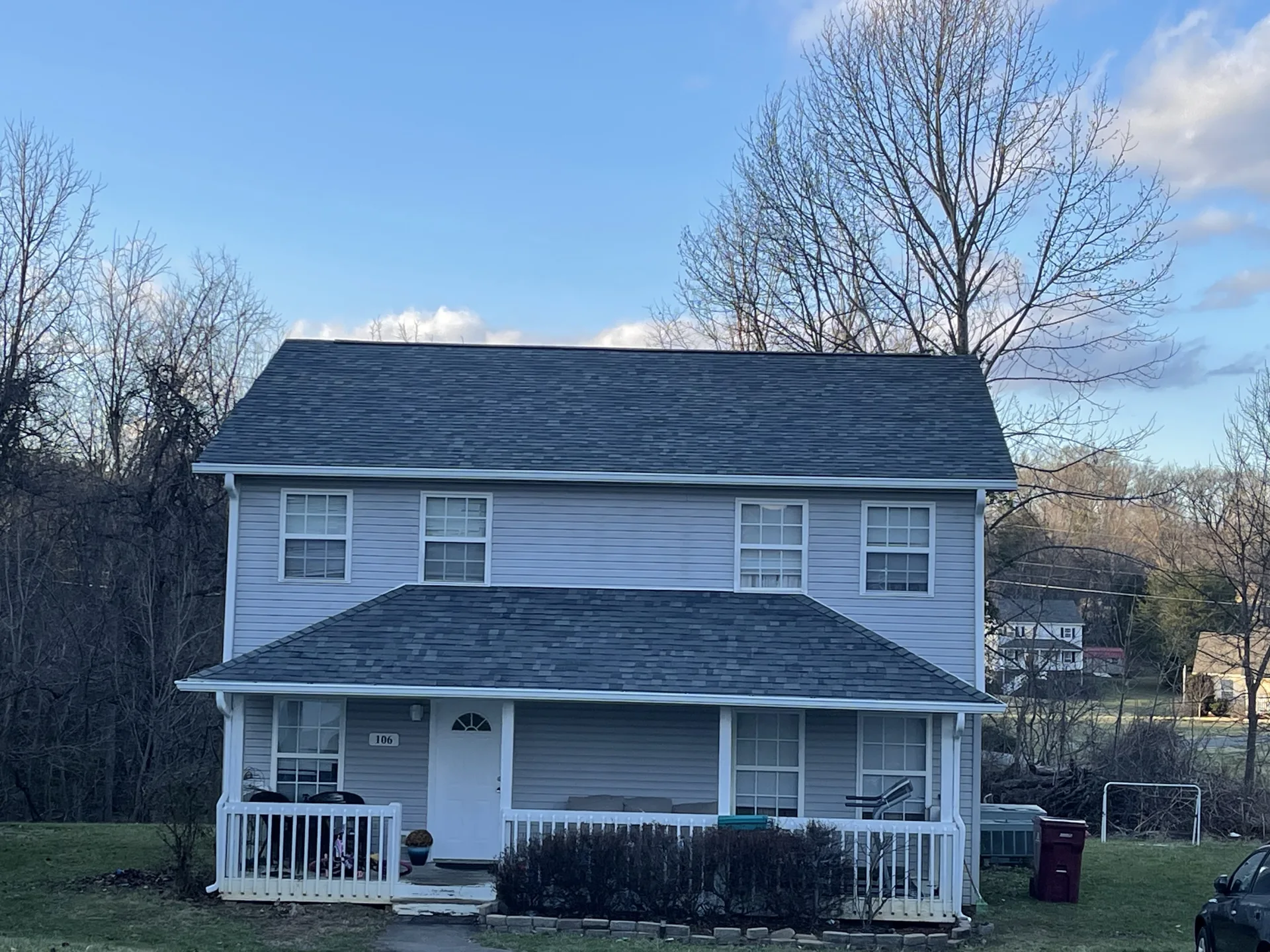 Two-story home with a dark shingle roof and covered front porch