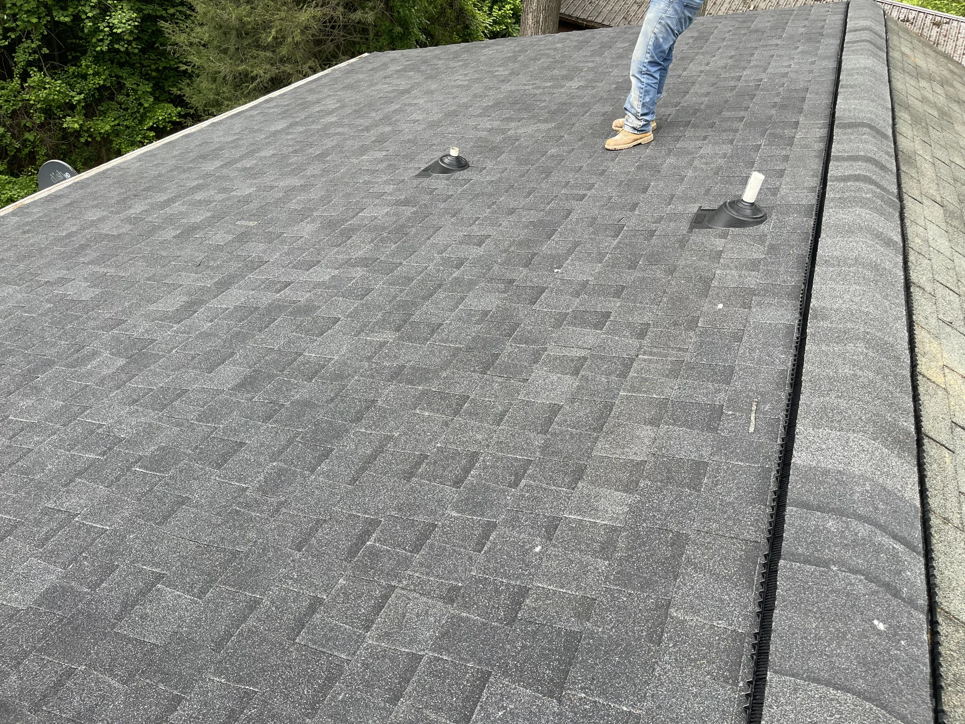 Close view of newly laid gray shingles along a roof edge