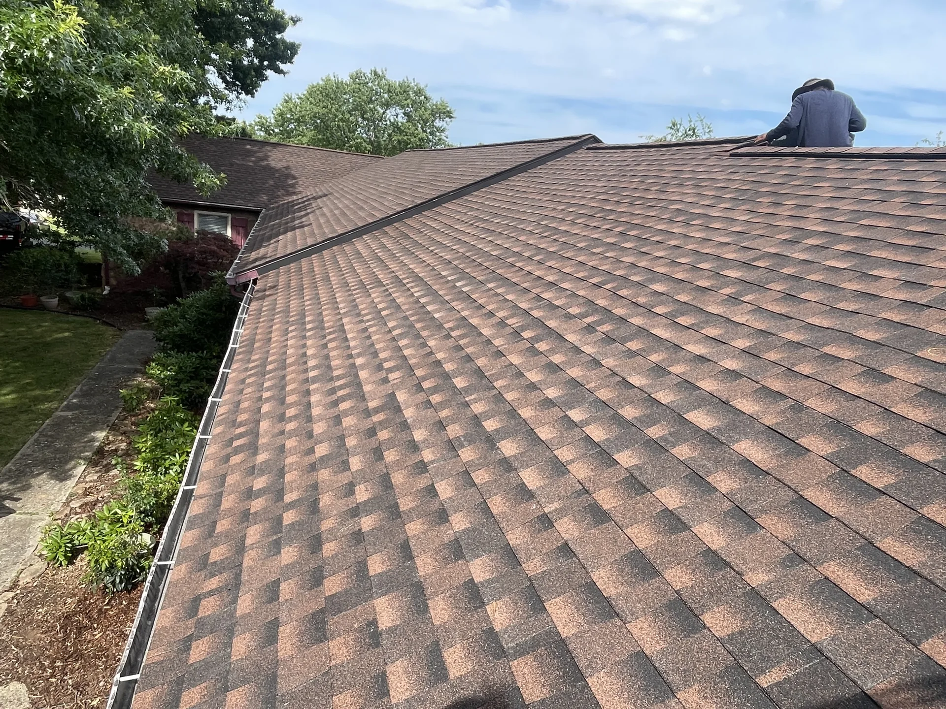 Close view of brown architectural shingles on a sloping roof