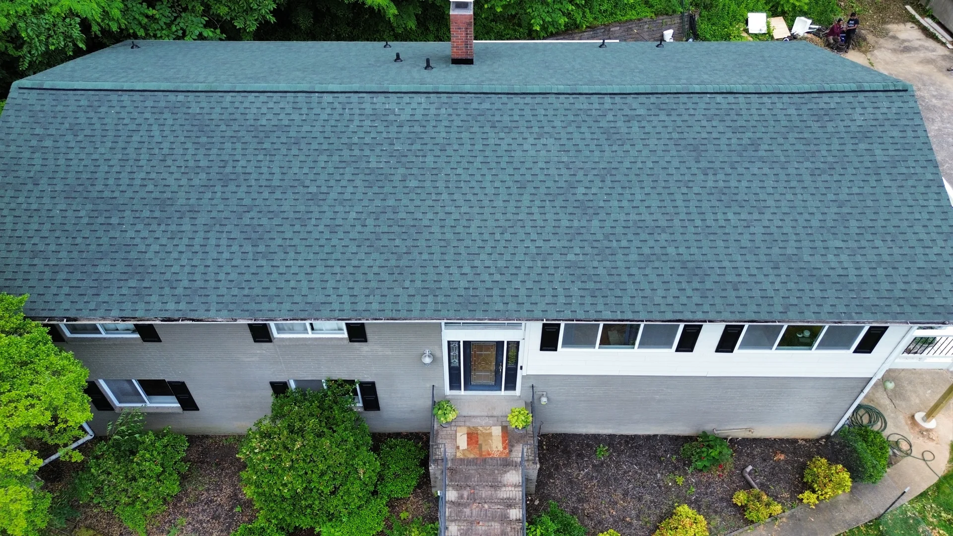 Overhead view of a long shingle roof on a white home
